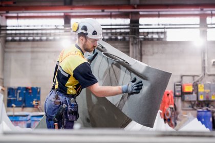 En medarbetare sätter skyddsfilt på den svängda trappan, tillverkad i Norberg.